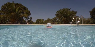 小女孩在度假村的游泳池里玩耍