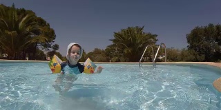 小女孩在度假村的游泳池里玩耍