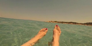 海滩上有问题的脚。女人在水里放松。
