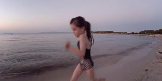日落时分，小女孩在海滩上奔跑