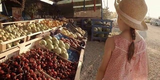 小女孩在农贸市场挑选水果