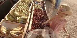 小女孩在农贸市场挑选水果