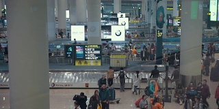 中国北京国际机场，飞机旅客正在传送带上等待他们的行李
