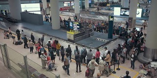 中国北京国际机场，飞机旅客正在传送带上等待他们的行李