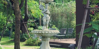 在夏天的背景花园喷溅喷泉