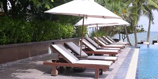 热带度假村游泳池附近的沙滩椅
