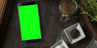黑色智能手机在桌面色度键绿色屏幕