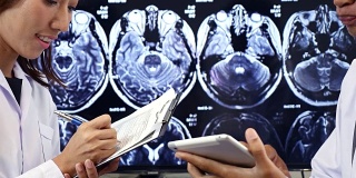 两位医生在数字平板电脑上讨论核磁共振扫描