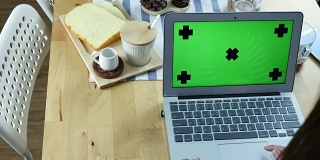 Over the Shoulder view of Woman Using Laptop with Green screen with Breakfast, Chroma key