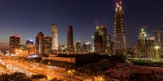 T/L WS HA ZI鸟瞰图北京CBD区域和大型建筑工地与起重机，黄昏到夜晚过渡