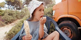 沙滩上的小女孩吃冰淇淋，弄得一团糟。