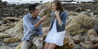 多民族浪漫情侣在海滩吃寿司