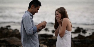 多民族浪漫情侣在海滩求婚