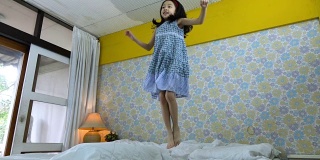 小女孩在家里的床上跳的慢镜头