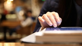 一名女子在图书馆用平板电脑阅读电子书视频素材模板下载