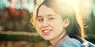 16岁的漂亮女孩的视频肖像谁在户外，在后院，在秋天。