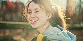 16岁的漂亮女孩的视频肖像谁在户外，在后院，在秋天。