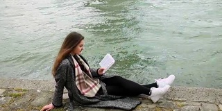 一个年轻女子在塞纳河沿岸看书