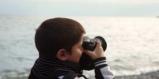 一个男孩拿着相机拍了一张风景照