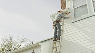 建筑工人爬上梯子，在住宅上干活视频素材模板下载