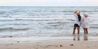 一对女孩享受和放松在海滩上