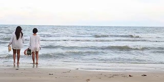 一对女孩享受和放松在海滩上