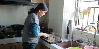 家庭烹饪:一位老年妇女在切蔬菜