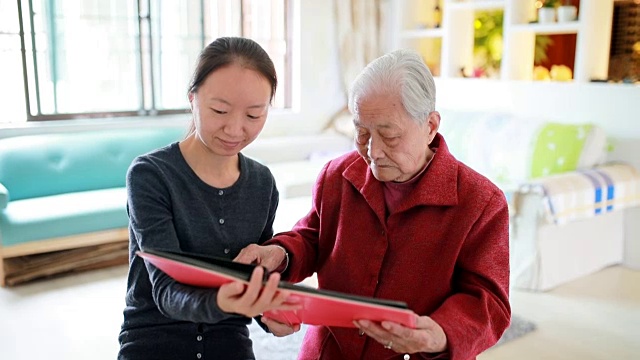 孙女和奶奶坐在一起看老照片。