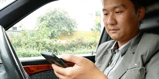一名司机在车上使用智能手机