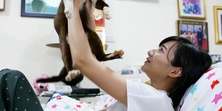 亚洲女孩在家里抱着她的猫