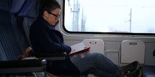年轻女子在火车上看书