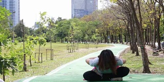 亚洲女人在花园里练瑜伽