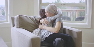 患有癌症的年轻女性拥抱着她的女儿