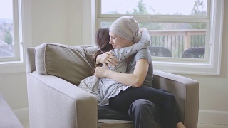 患有癌症的年轻女性拥抱着她的女儿视频素材模板下载
