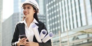 带着头盔微笑的女工程师在建筑工地的镜头前的肖像