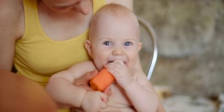 小男孩嚼着一根橙色的胡萝卜