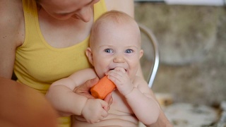 小男孩嚼着一根橙色的胡萝卜视频素材模板下载