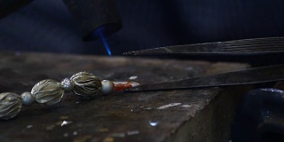 男人手工制作的银项链用煤气燃烧来粘合