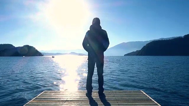 日出时站在湖岸上的人