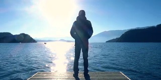 日出时站在湖岸上的人