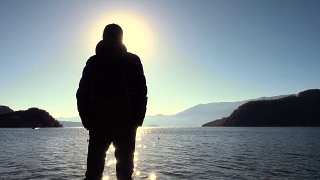 日出时站在湖岸上的人视频素材模板下载