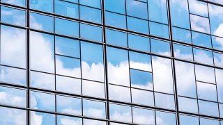 在蓝色的天空中有玻璃幕墙的现代蓝色建筑视频素材模板下载