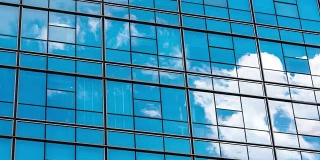 在蓝色的天空中有玻璃幕墙的现代蓝色建筑