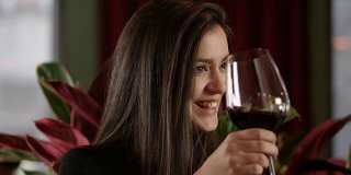 年轻女子享受4K慢动作与一杯红酒