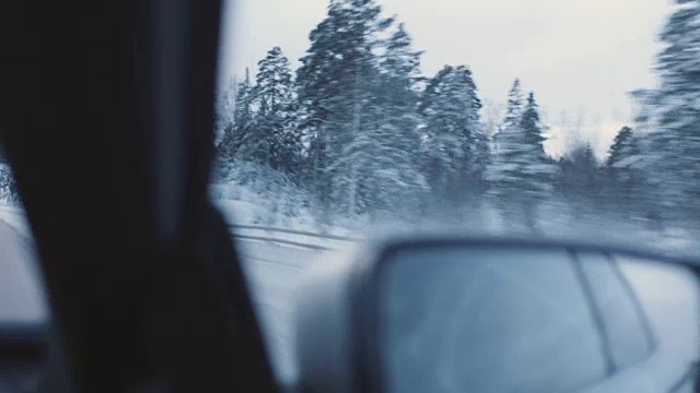 一辆汽车通过一个冬天的风景手持式拍摄