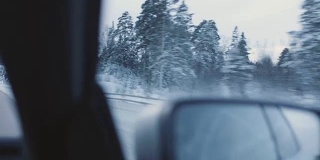一辆汽车通过一个冬天的风景手持式拍摄