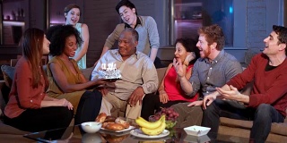 生日快乐!与家人和年轻的朋友一起庆祝黑人老人的生日。