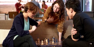 与朋友和家人一起玩乐。象棋游戏:朋友们下棋，当其他人在做食物的时候，一个十几岁的女孩在做建议。