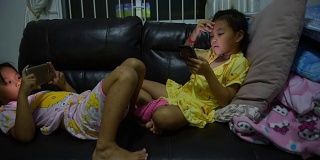 年轻的东南亚女孩在智能手机上玩电子游戏
