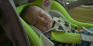小婴儿睡在安全座椅上。